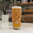 Load image into Gallery viewer, A photo of the back of a gweilo beer 50cl glass featuring stencils by urban artist szabotage